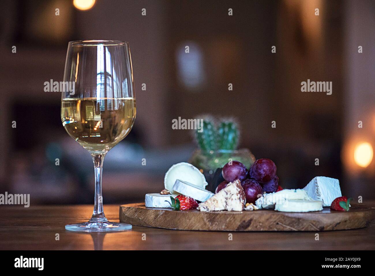 Verre de vin blanc à côté d'une planche à fromage Banque D'Images