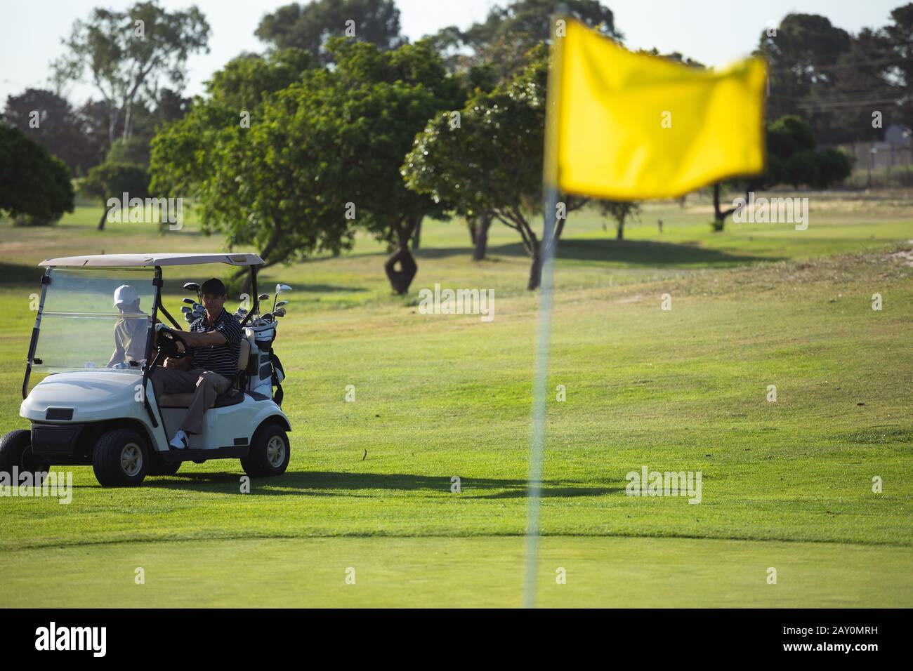 Les golfeurs qui conduisent le buggy de golf Banque D'Images