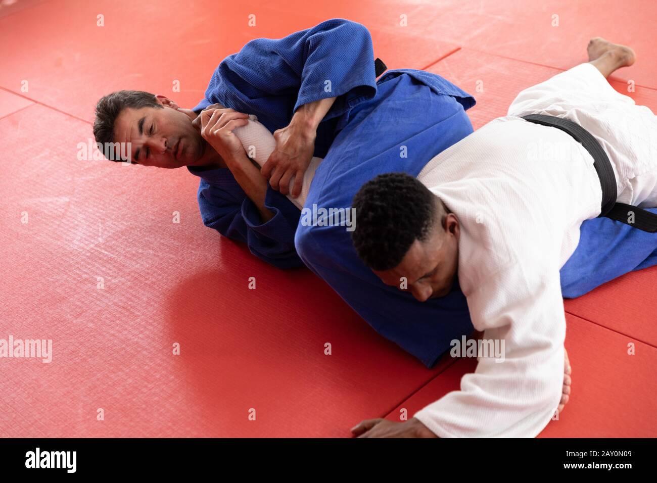 Judokas pratiquant le judo pendant un sparing dans une salle de sport Banque D'Images