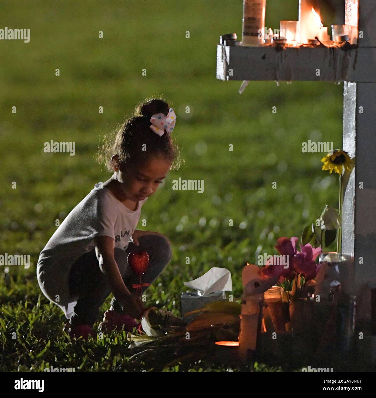 Parc, FL - 16 février : une jeune femme met des fleurs sur un mémorial qui honore les victimes de la prise de masse à l'école secondaire Marjory Stoneman Douglas, à Pine Trail Park le 16 février 2018 dans un parc, en Floride. La police a arrêté 19 ans, ancien élève Nikolas Cruz pour avoir tué 17 personnes à l'école secondaire. Personnes : Atmosphère Banque D'Images
