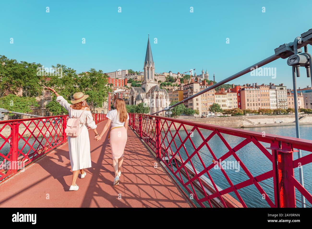 Deux jeunes filles amis marchant sur le pont piétonnier Saint Georges en voyageant dans la vieille ville de Lyon en France Banque D'Images