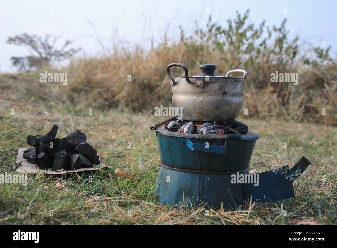 Cuisine traditionnelle charbon de bois et potventral poêle en Afrique sur la nature dans une poêle. Banque D'Images