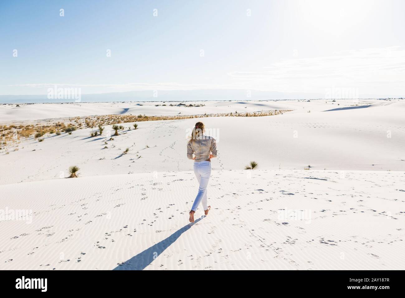 fille de 13 ans debout regardant un vaste espace ouvert de dunes de sable. Banque D'Images