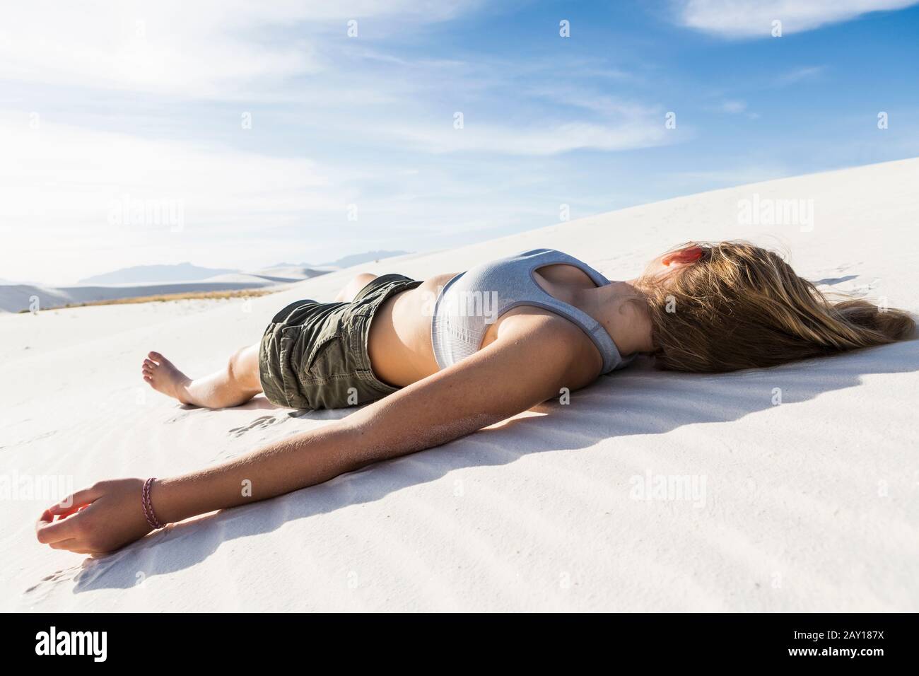 Une adolescente allongé sur son dos sur le sable blanc lisse White Sands NAT'l Monument, NM Banque D'Images