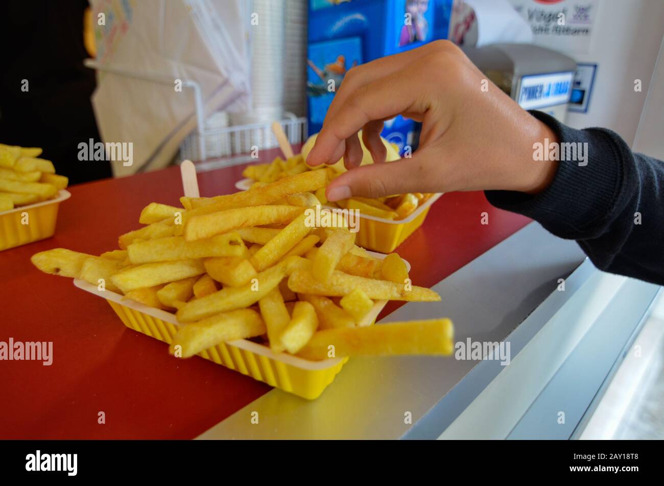 Oosterscheldekering, Pays-Bas, Août 2019. Le plat principal d'un kiosque à cuisine de rue : frites. Une partie est prête à être dégustée, une main est t Banque D'Images