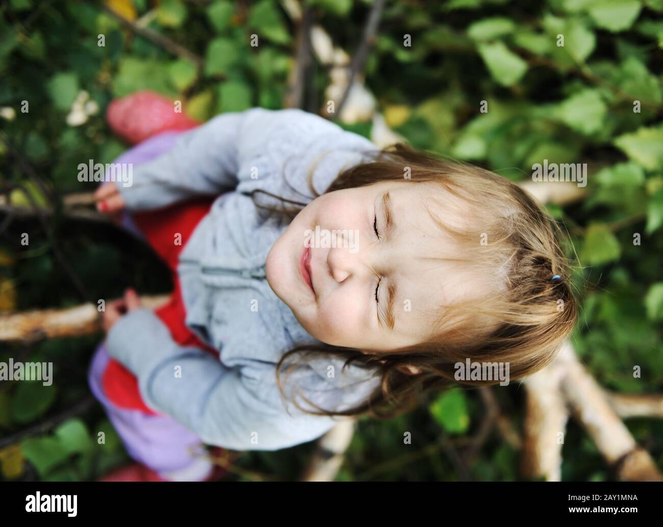 Beau Bebe Blond Sur Les Feuilles D Arbre Avec Les Yeux Fermes Photo Stock Alamy