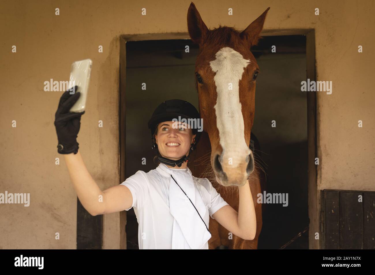 Femme caucasienne prenant des selfies avec son cheval de dressage Banque D'Images