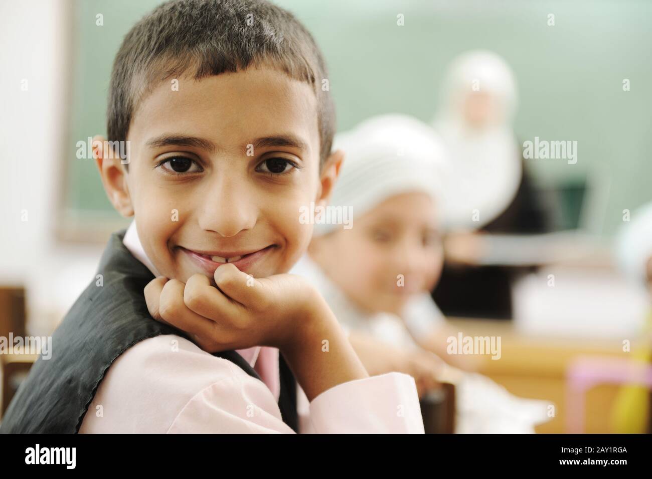 Enfant positif en classe souriant et regardant dans l'appareil photo Banque D'Images