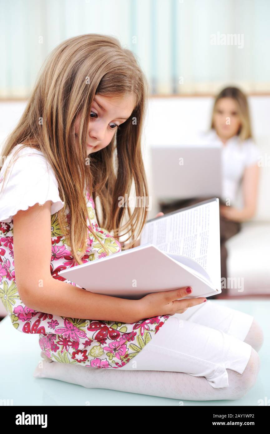 Petite fille lecture à la maison Banque D'Images