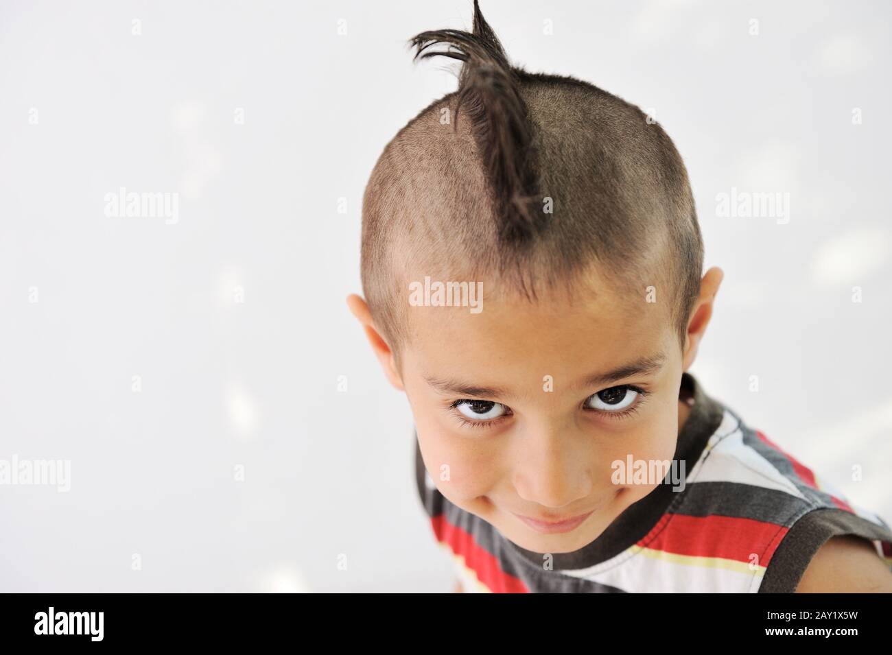 Joli petit garçon avec des cheveux et de la grimace drôle Banque D'Images