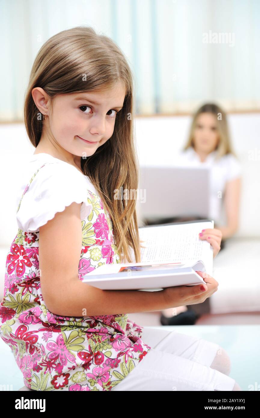 Petite fille lecture à la maison Banque D'Images