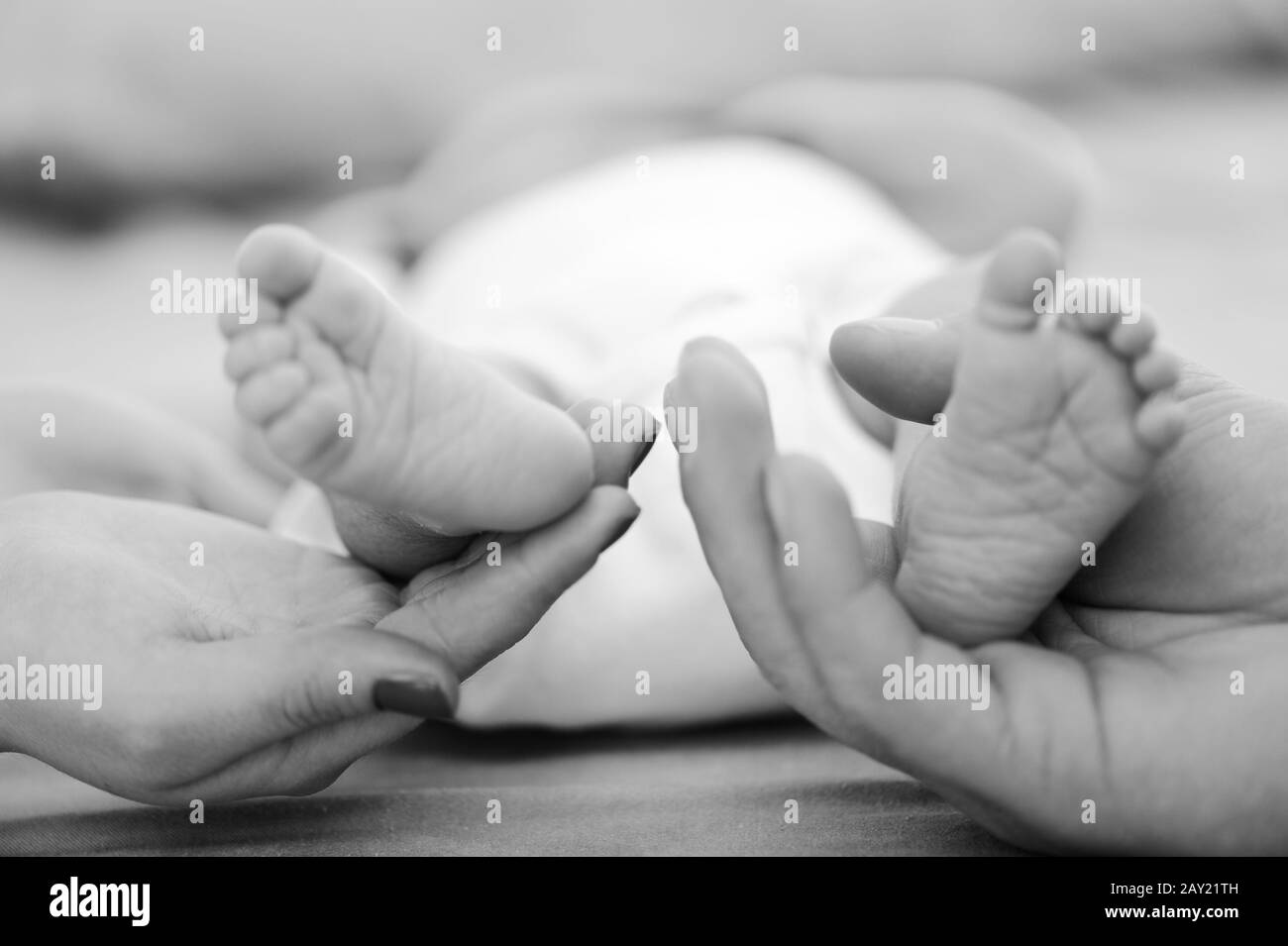 Les parents tiennent les pieds de bébé Banque D'Images