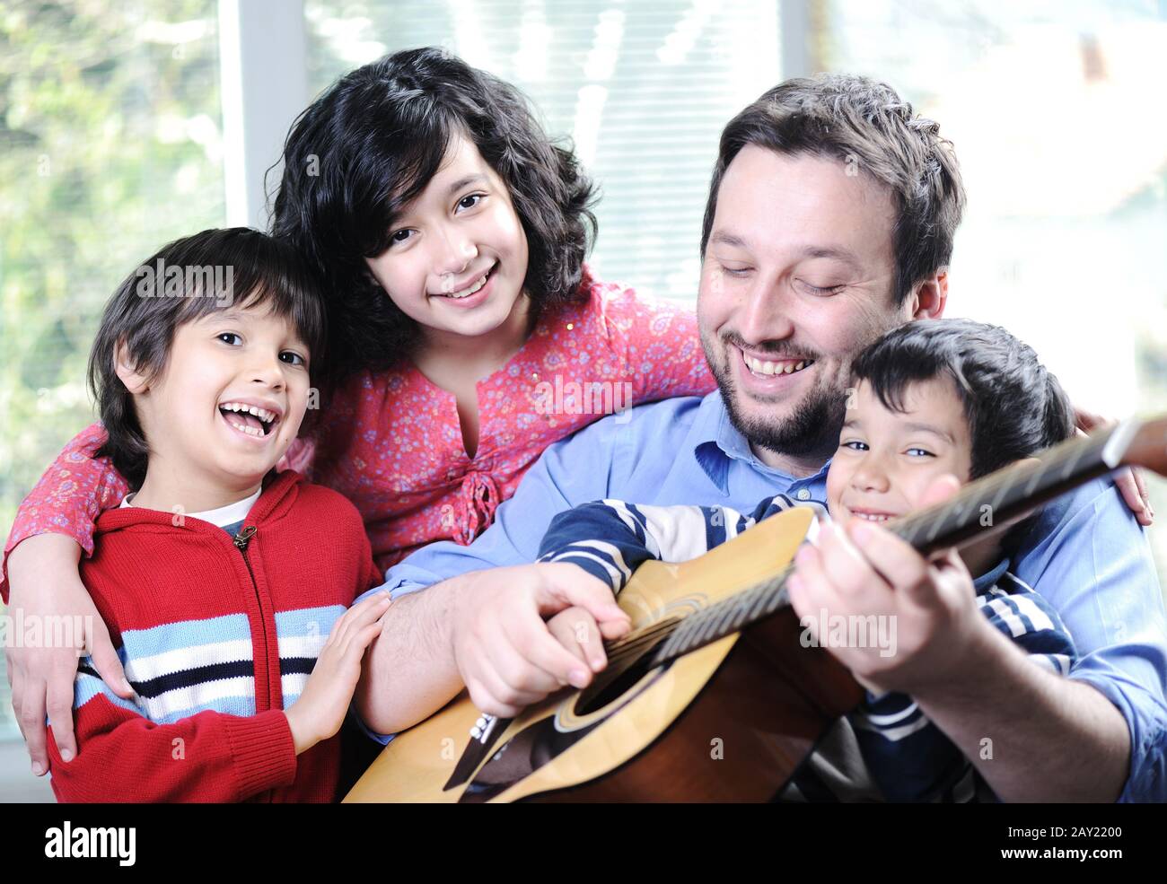 Bonne famille jouant de la guitare ensemble à la maison Banque D'Images