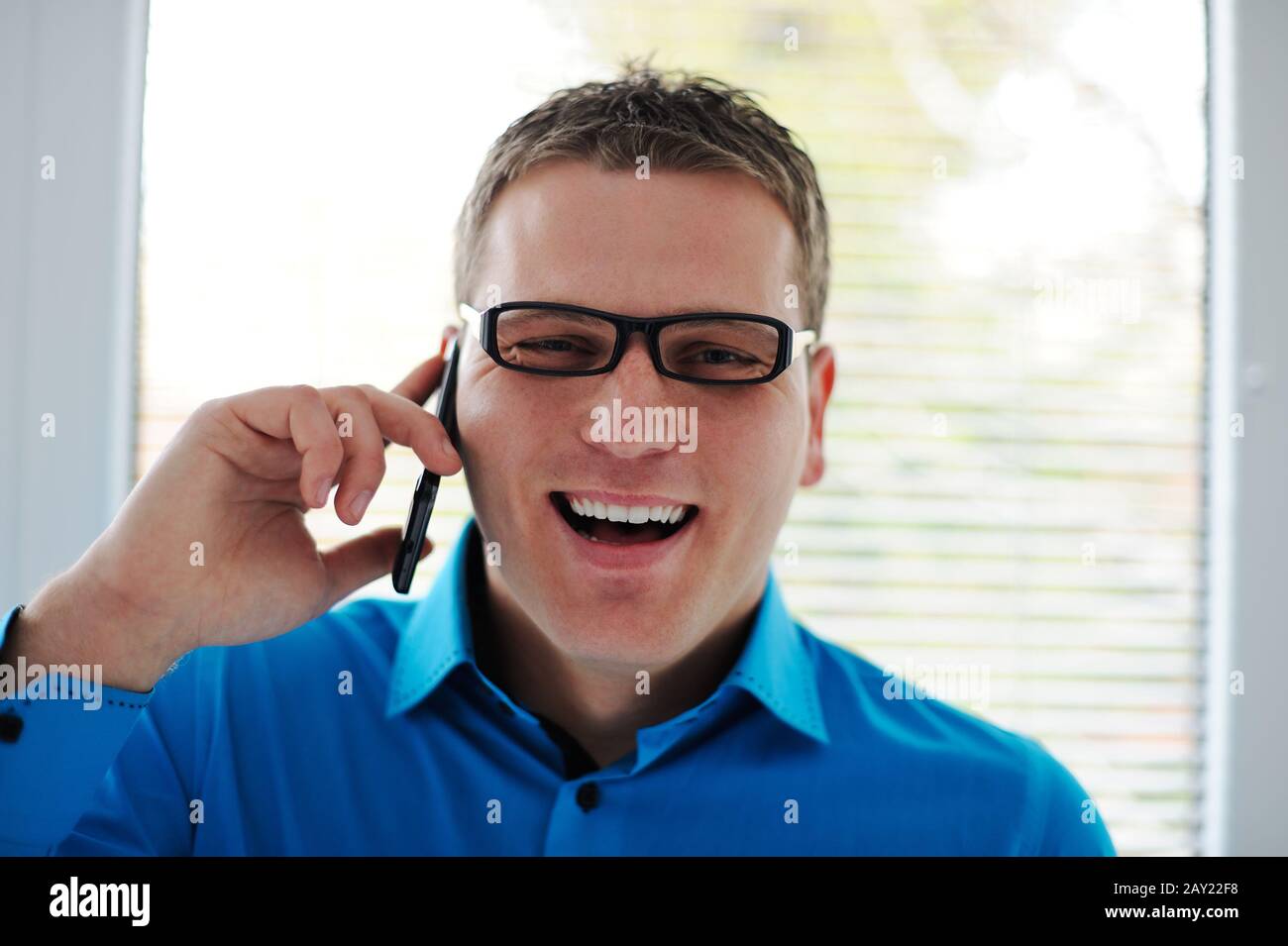 Portrait d'un jeune homme heureux parlant sur un téléphone portable Banque D'Images