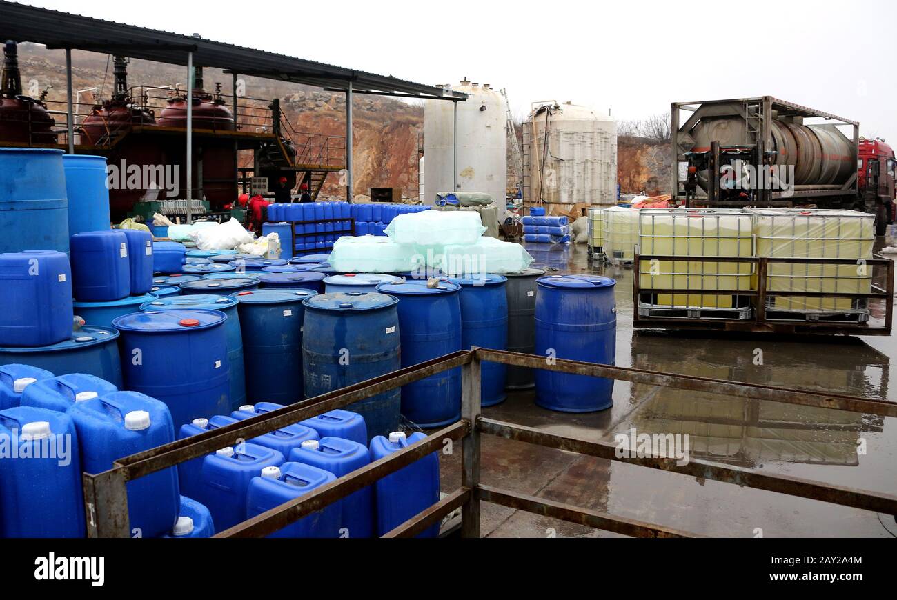 Les travailleurs chinois empilent des seaux de désinfectant nouvellement fabriqué à l'usine d'une société locale de technologie de traitement de l'eau pendant l'éclosion de Banque D'Images