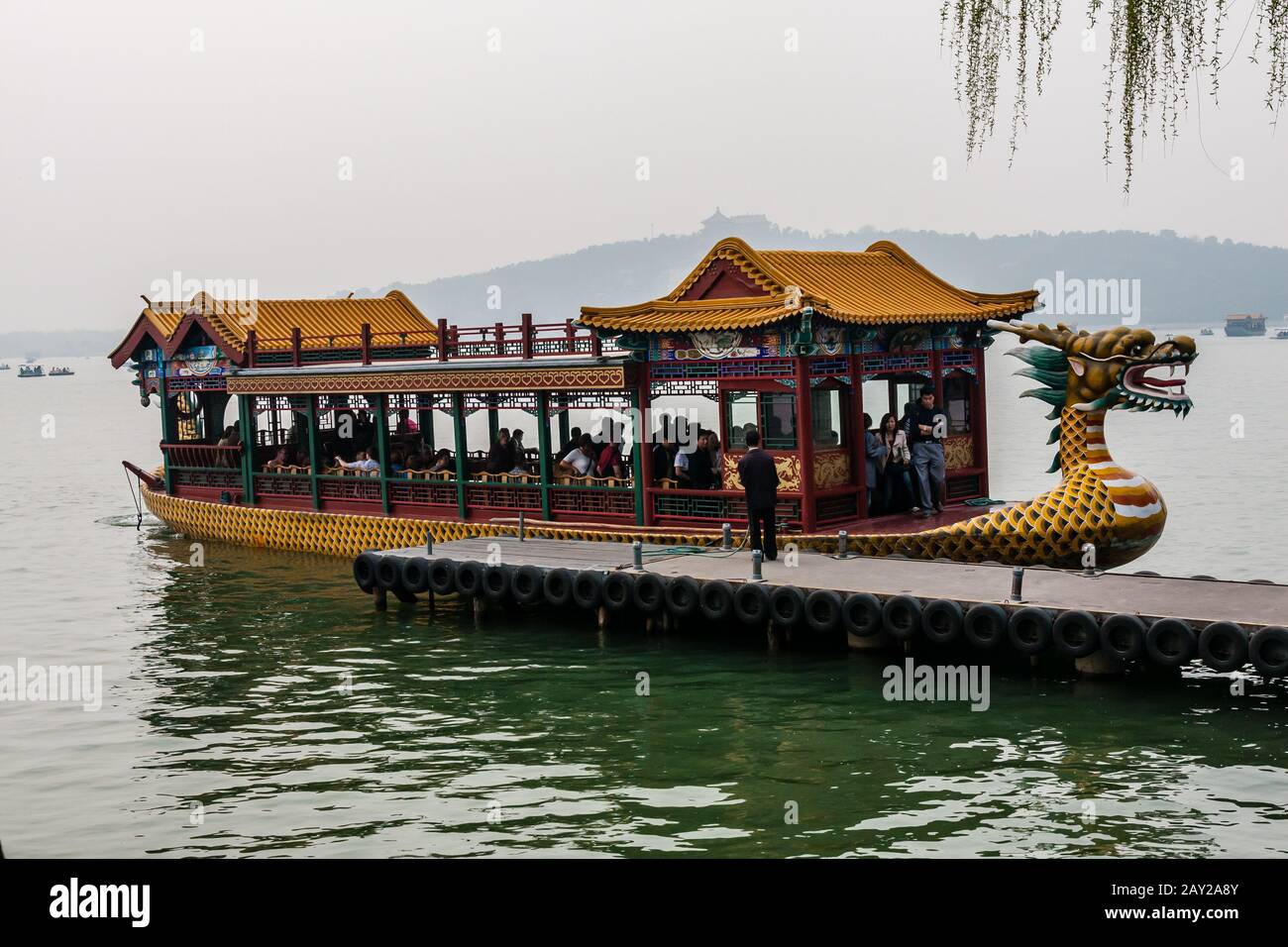 Un bateau de croisière en bois richement décoré avec des touristes amarrés à un quai sur le lac de Kunming, Pékin Banque D'Images