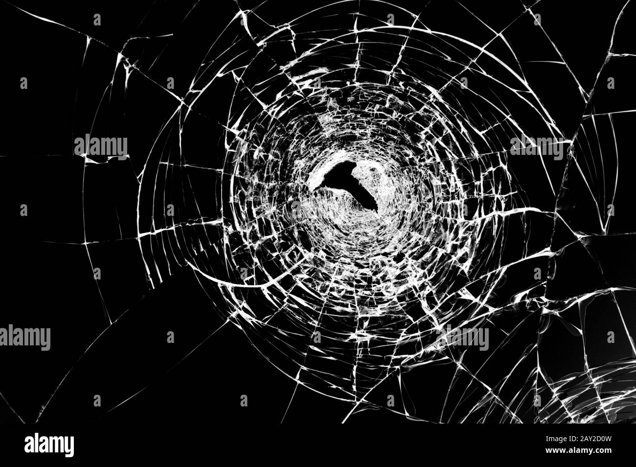 Texture de verre brisé fissuré avec un trou, fissuré par impact. Concept tourné dans la fenêtre sur un arrière-plan noir pour le design. Banque D'Images