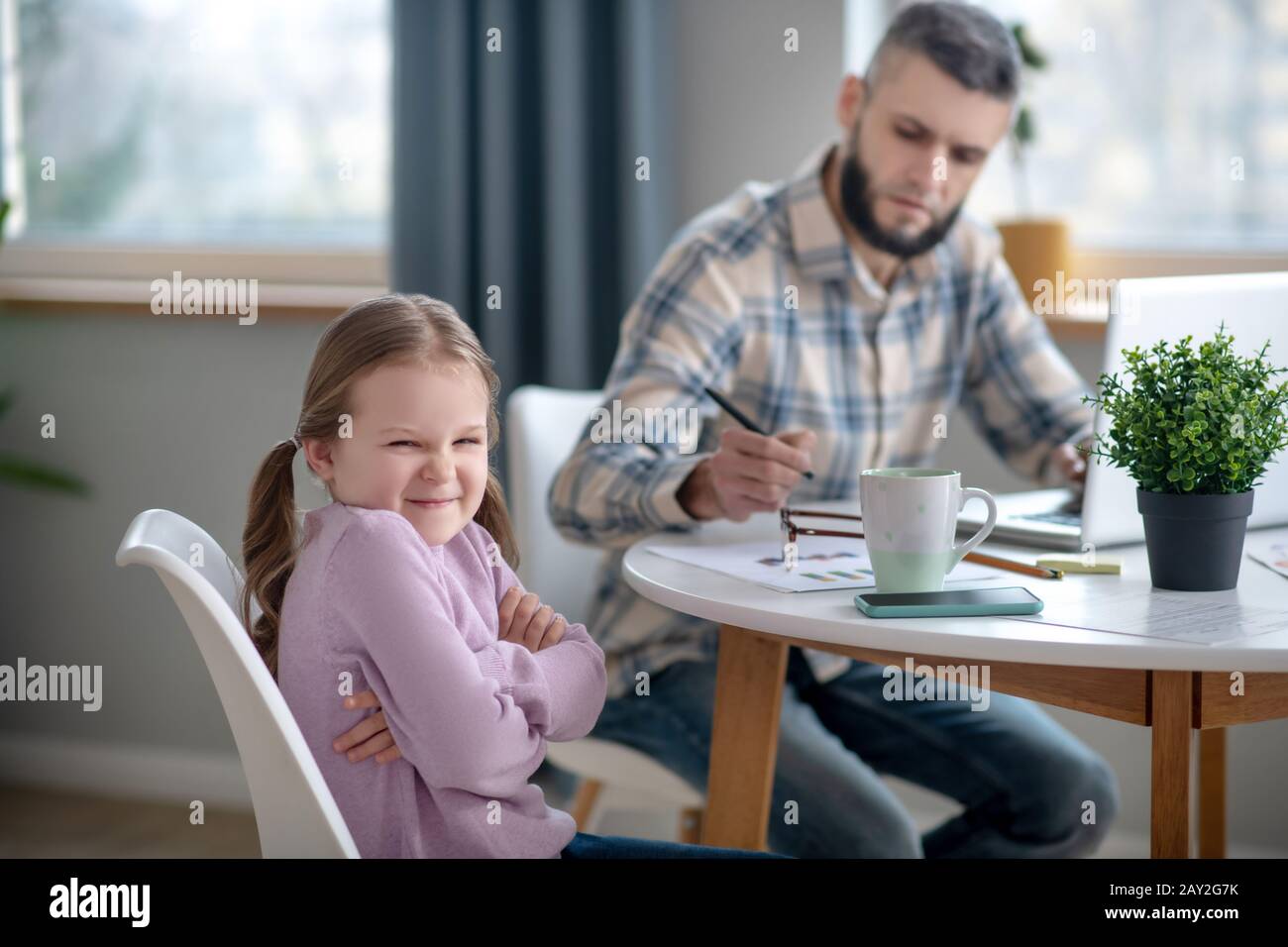 Petite fille et jeune père assis à la table à la maison. Banque D'Images