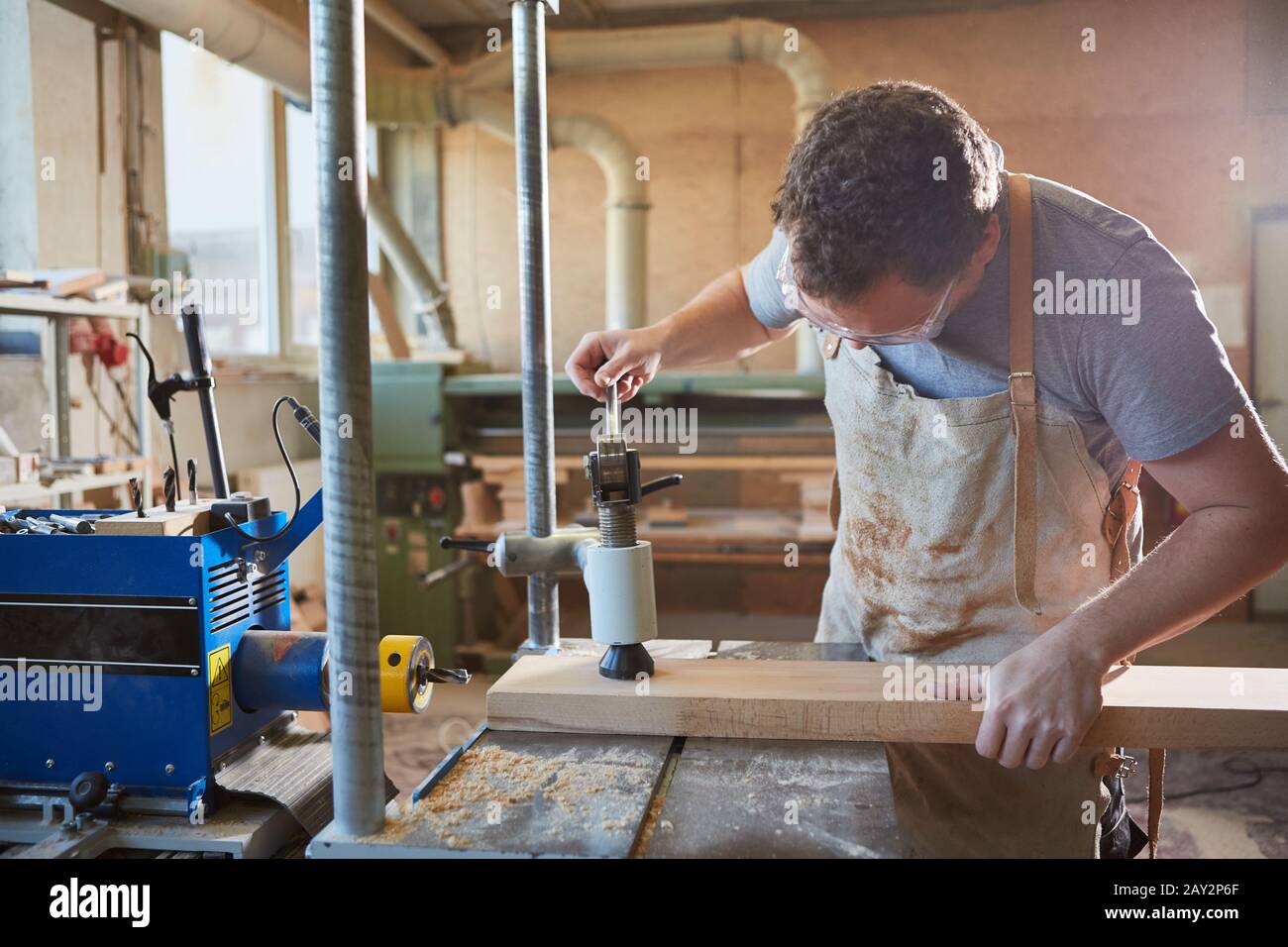 Carpenter comme un fabricant de meubles travaille avec la planche en bois sur un foret Banque D'Images