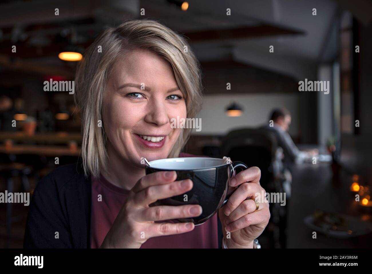 Femme souriante tenant une tasse de thé Banque D'Images
