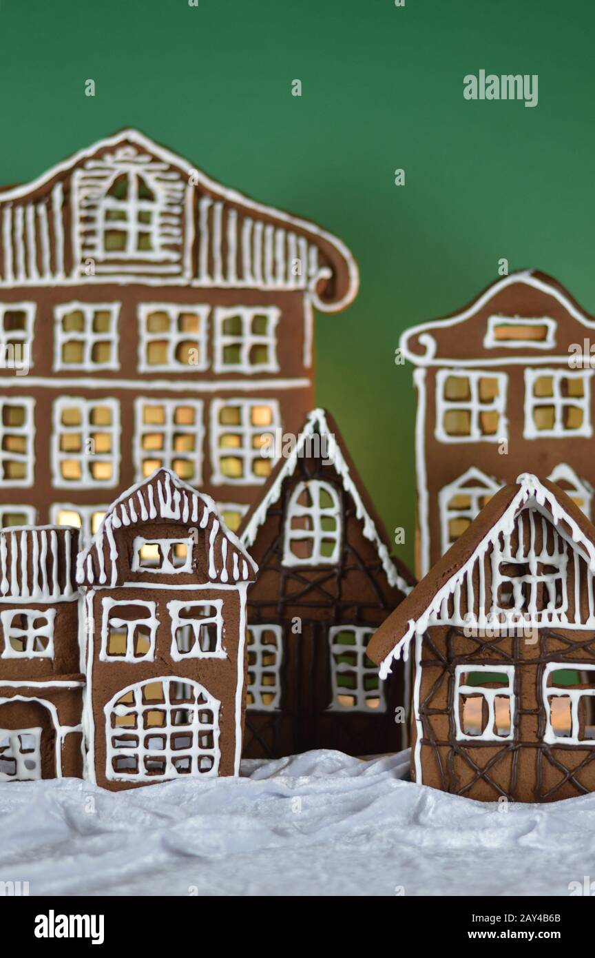 maison a fait traditionnel sucré délicieux village de pain d'épice cuit au four en face de fond vert sur le velours blanc de neige comme la décoration de noël pour le Banque D'Images