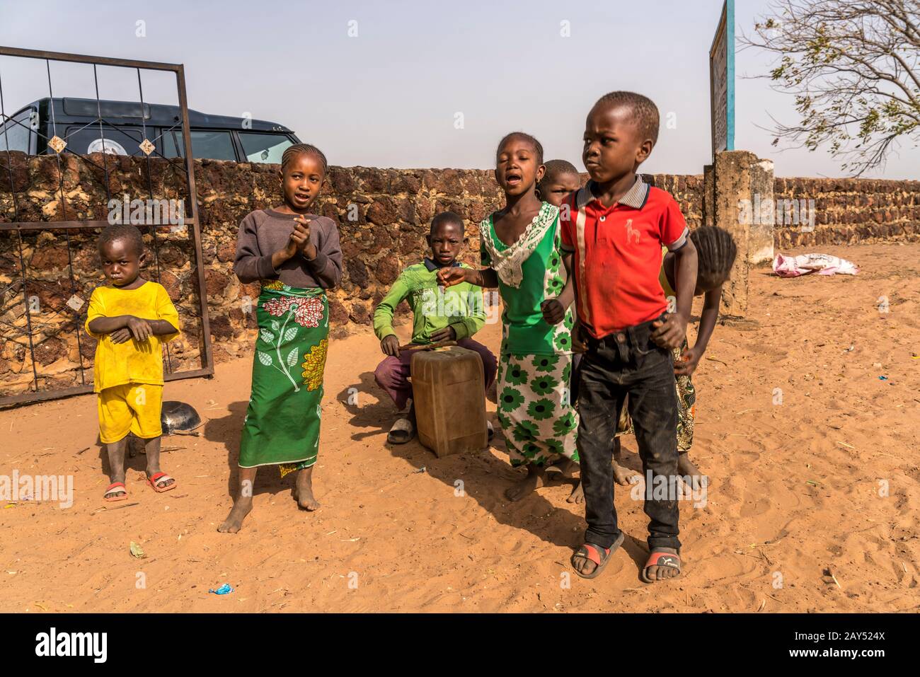 Eine Gruppe afrikanischer Kinder mit selbstgenauter Trommel beim singen und spielen, Wassu, Gambie, Westafrika | groupe d'africains à tambour auto-fabriqué Banque D'Images