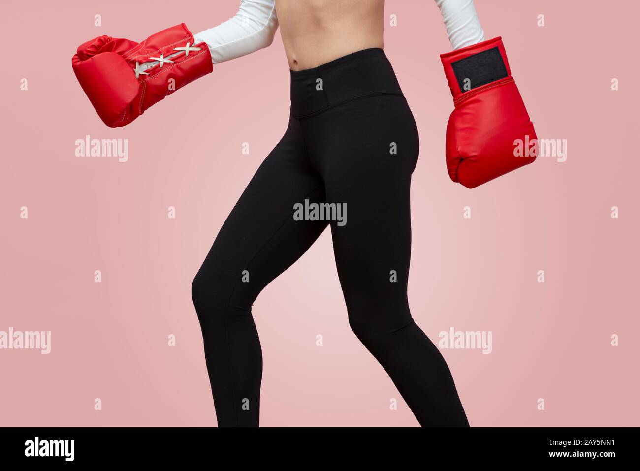 gros plan sur une femme sportive qui porte des gants de boxe, moitié inférieure uniquement. Banque D'Images