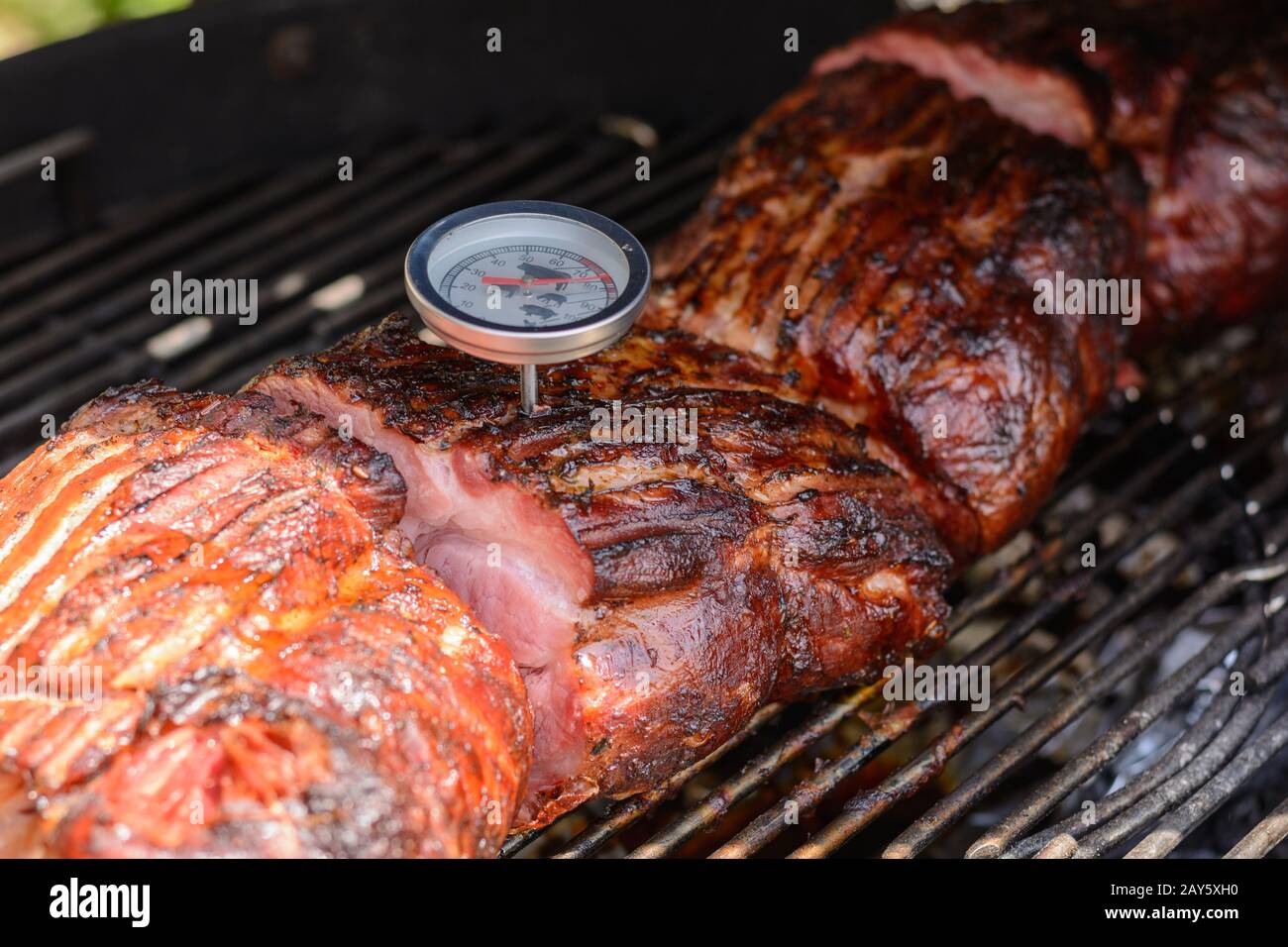 Avec thermomètre, la température de la viande est vérifiée sur le gril à boule Banque D'Images