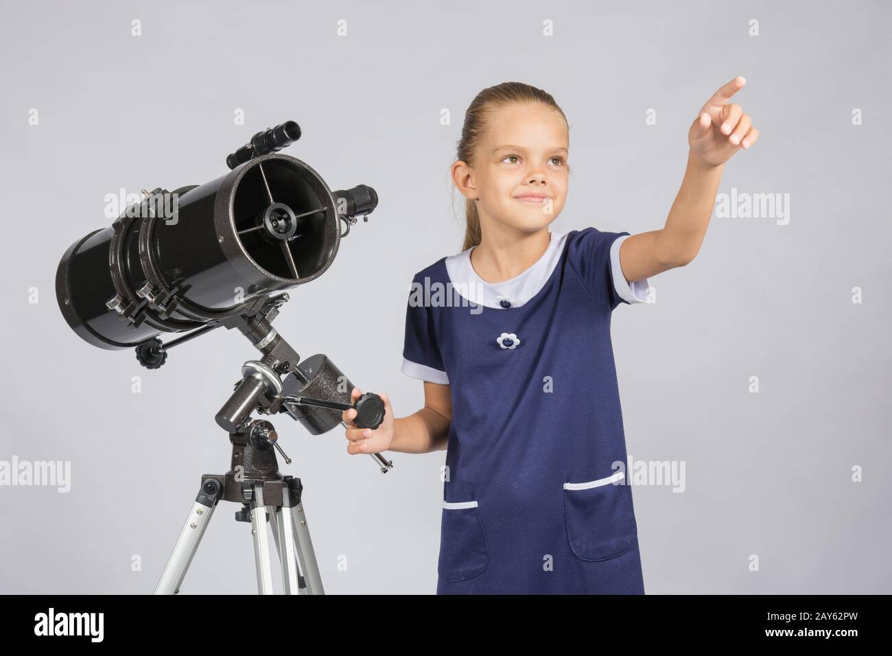 Le jeune astronome montre le ciel étoilé tout en se tenant au télescope Banque D'Images