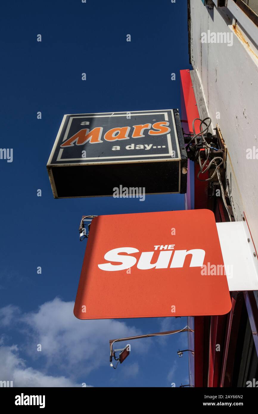 Journal britannique tabloïd le Sun et le panneau « A Mars A day » sont installés sur le mur extérieur d'un agent de presse dans le sud-est de Londres, Londres, Royaume-Uni Banque D'Images