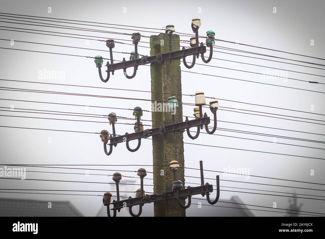 Poteau en béton avec vieux télégraphe et téléphon filaire ligne avec fond misty Banque D'Images