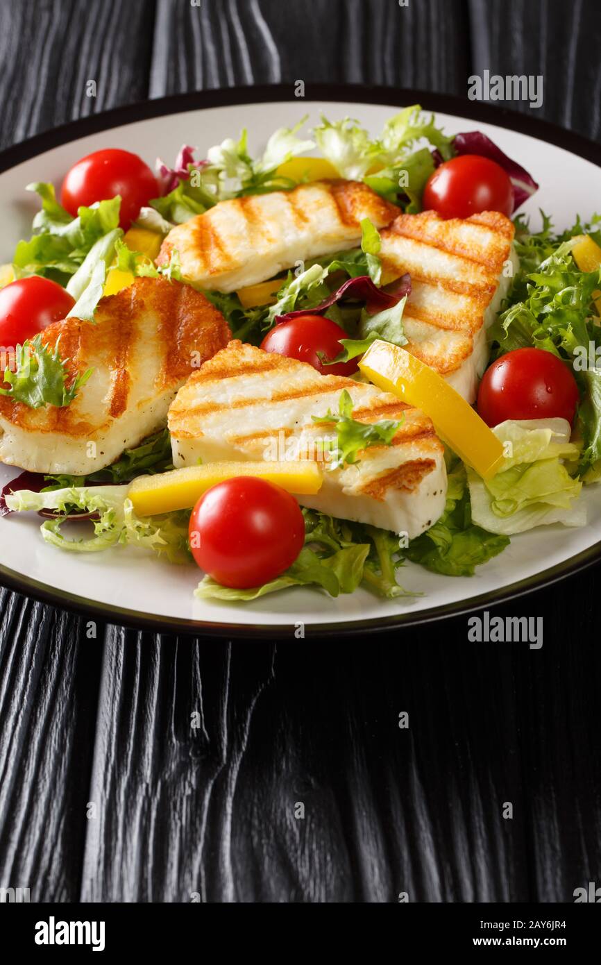 Salade chypriote de fromage hallucini grillé, tomates, poivrons et laitue se rapprochées dans une assiette sur la table. Verticale Banque D'Images