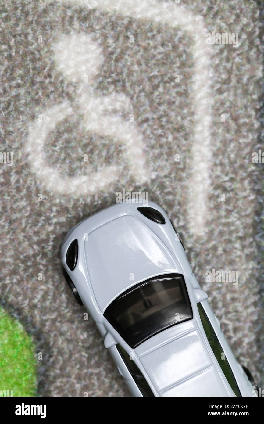 Le véhicule jouet est un parking pour personnes à mobilité réduite sur le tapis de la ville Banque D'Images Le véhicule jouet est un parking pour personnes à mobilité réduite sur le tapis de la ville Banque D'Images