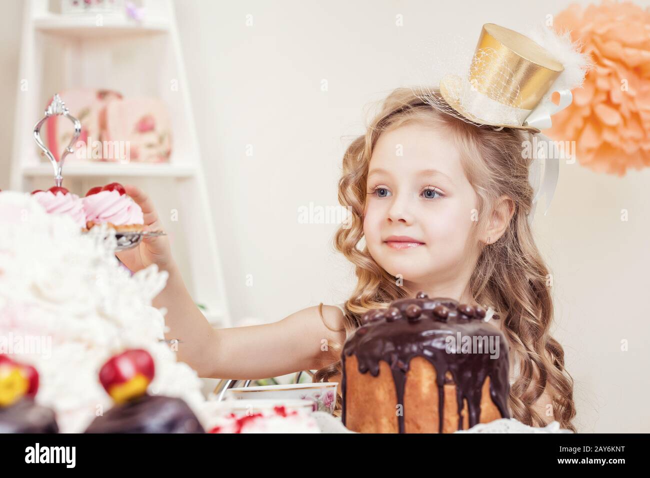 Smiling little girl posing in golden hat Banque D'Images