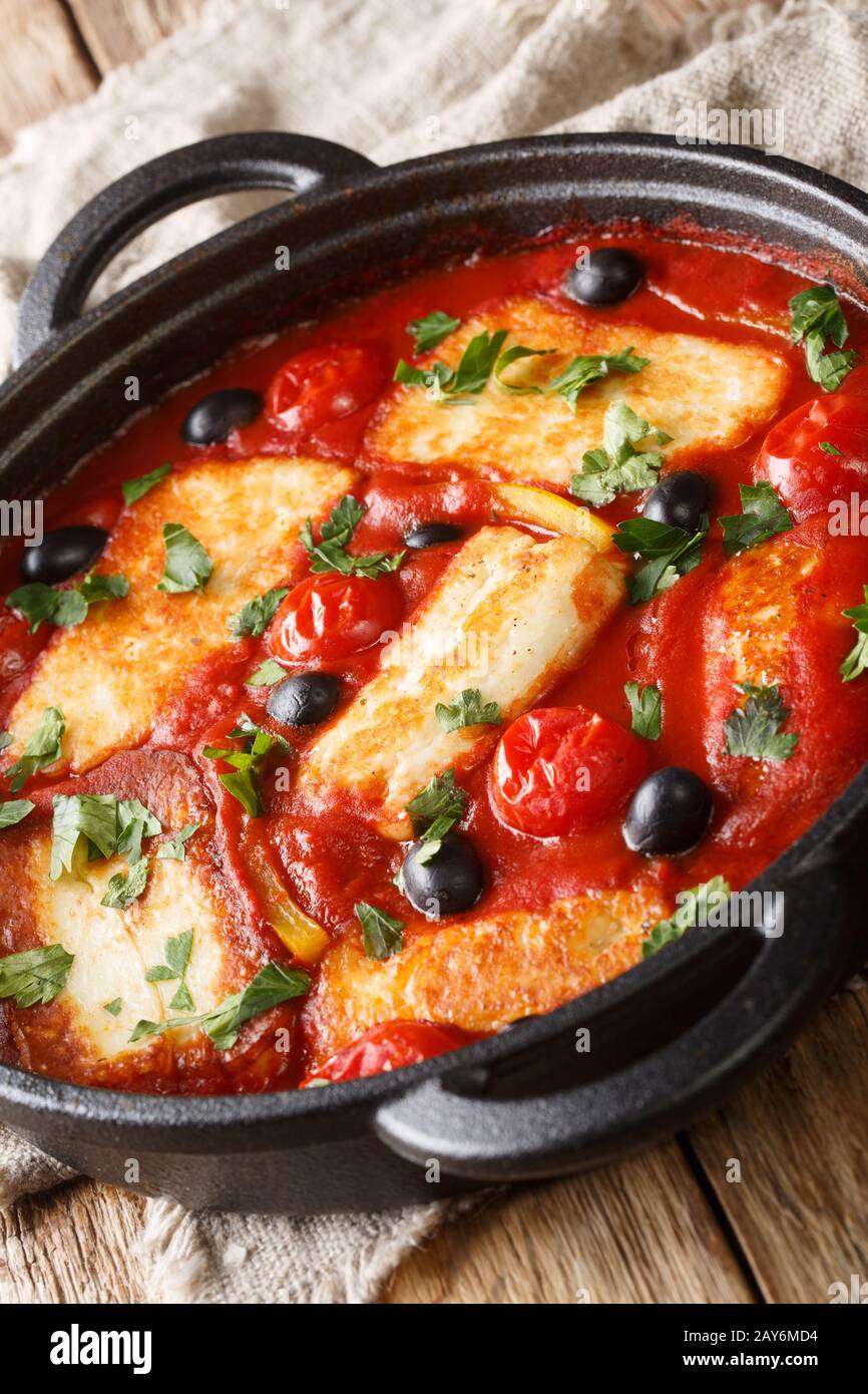 Fromage Halloumi cuit au four avec tomates, poivrons, olives près dans une poêle sur la table. Vertical Banque D'Images