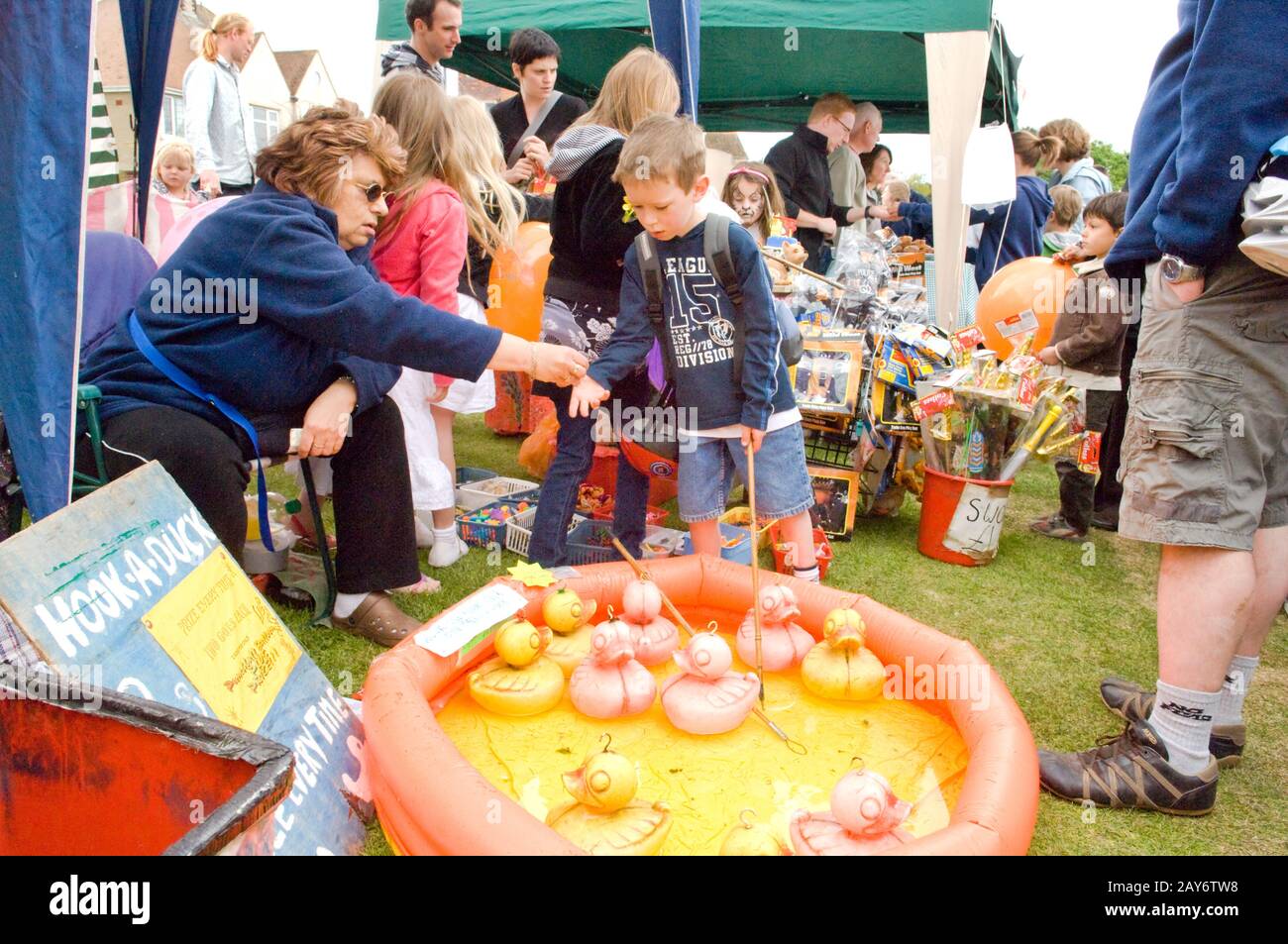 Jeune garçon sur le point de jouer au 'Hook-A-Duck' à une fête/foire locale Banque D'Images