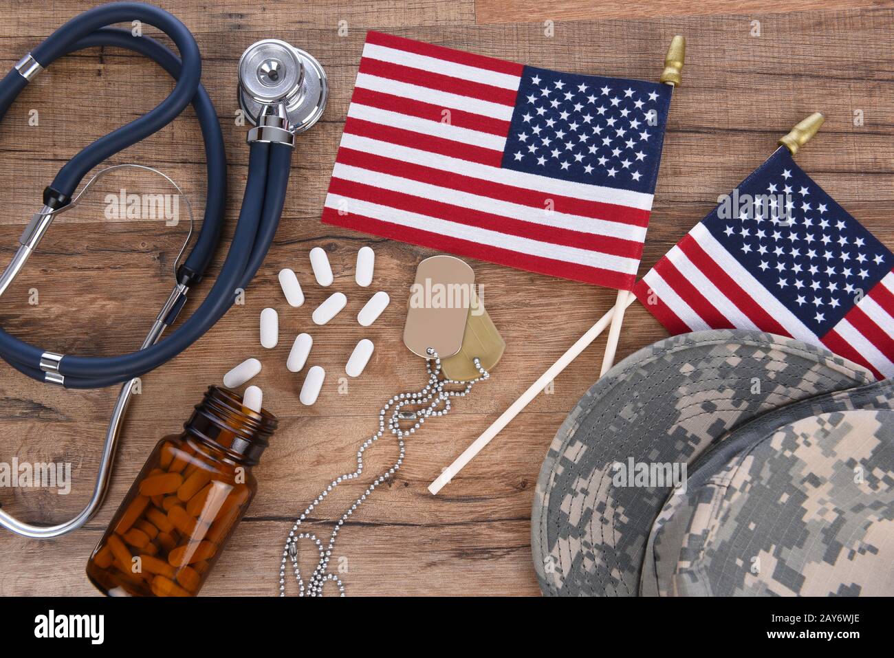 Concept De Soins De Santé Militaires. Chapeau de camouflage, étiquettes de chien, stéthoscope, pilules, et drapeaux américains sur un fond de bois. Banque D'Images