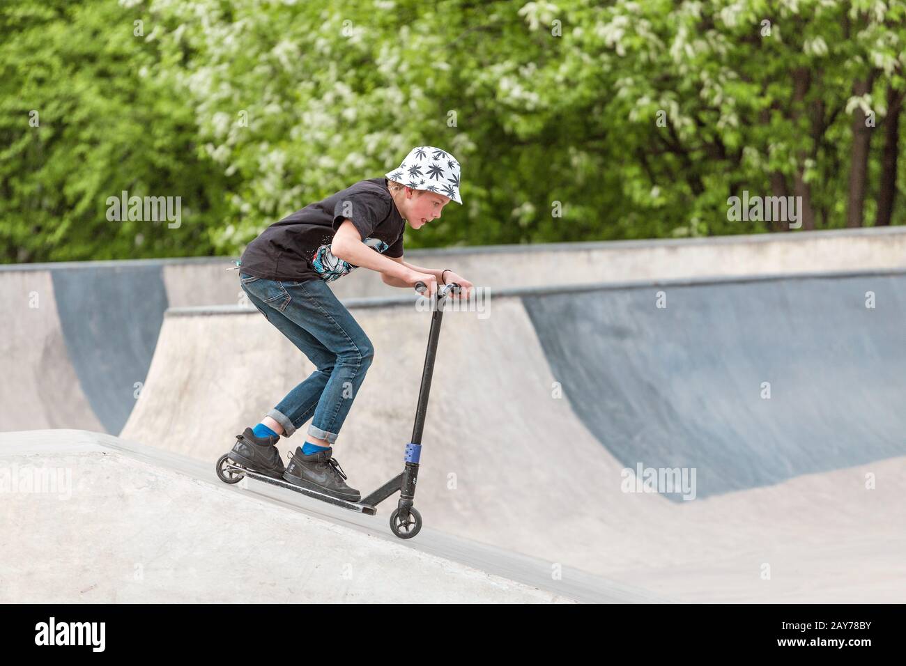 03 mai 2019, Moscou, Russie: Les enfants font du scooter dans un parc de skatepark sur des rampes et font quelques tours Banque D'Images