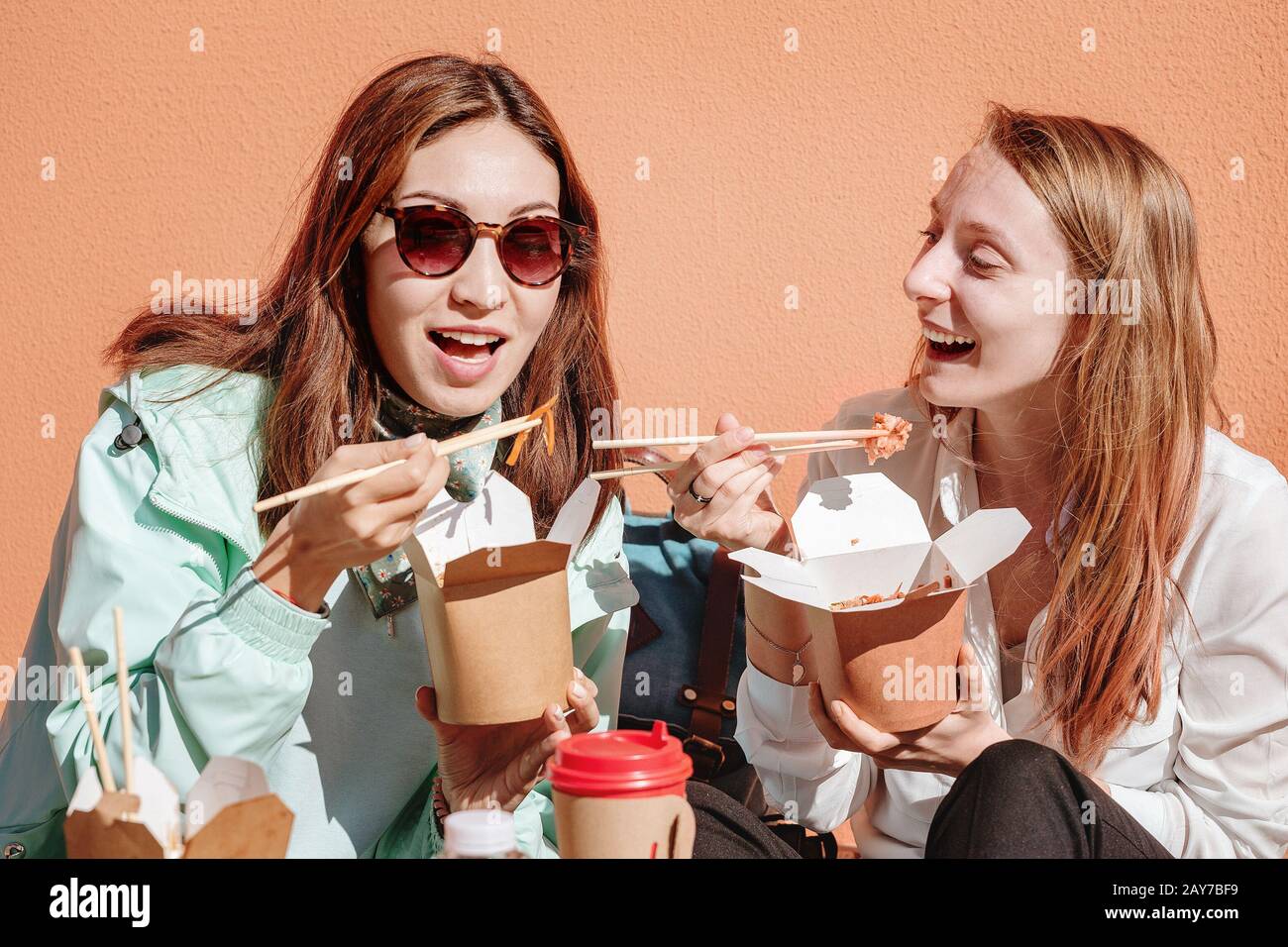 Deux amis filles mangent des nouilles wok du restaurant chinois dans la rue de la ville Banque D'Images
