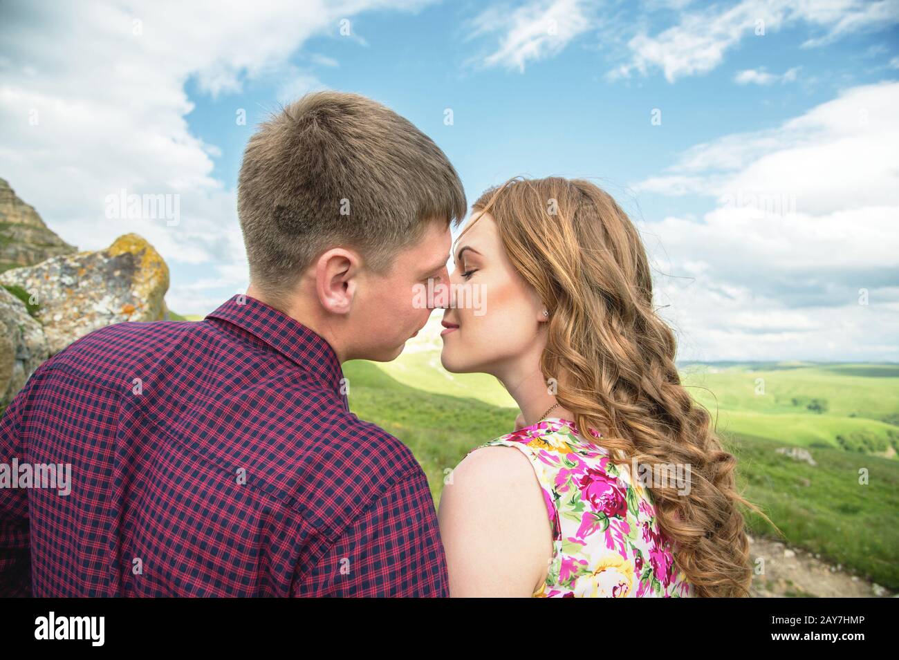 Un jeune couple marié atteint pour un baiser sur le fond d'une belle nature Banque D'Images