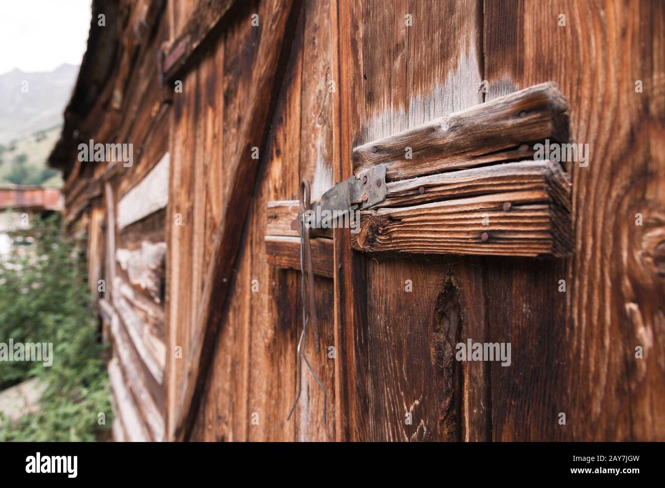 ancienne serrure simple sur une porte en bois fermée avec une goupille en métal rustique loquet sur une ancienne porte en bois Banque D'Images