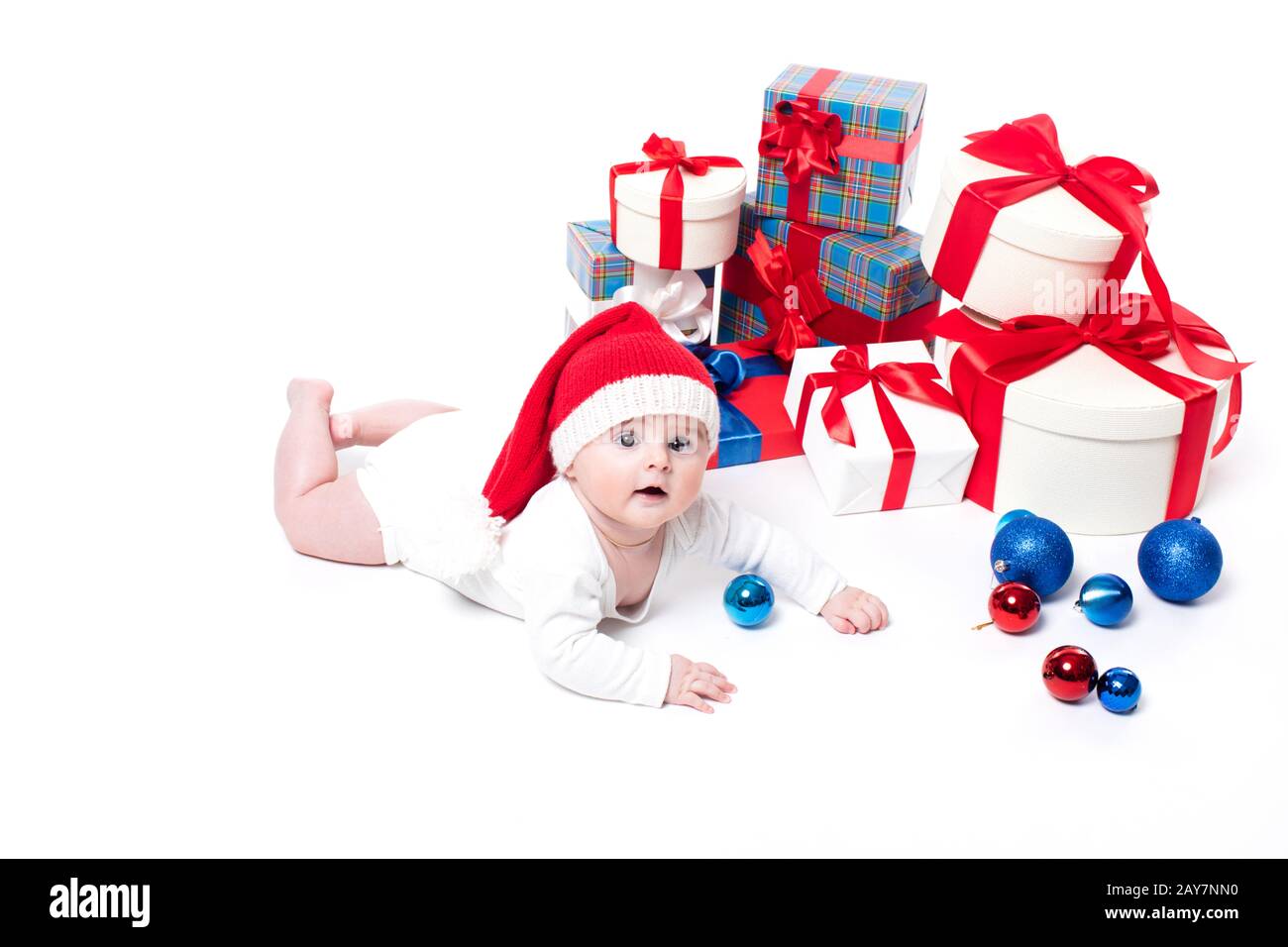 Bébé mignon dans une casquette rouge du nouvel an avec un sourire sur son visage allongé Banque D'Images