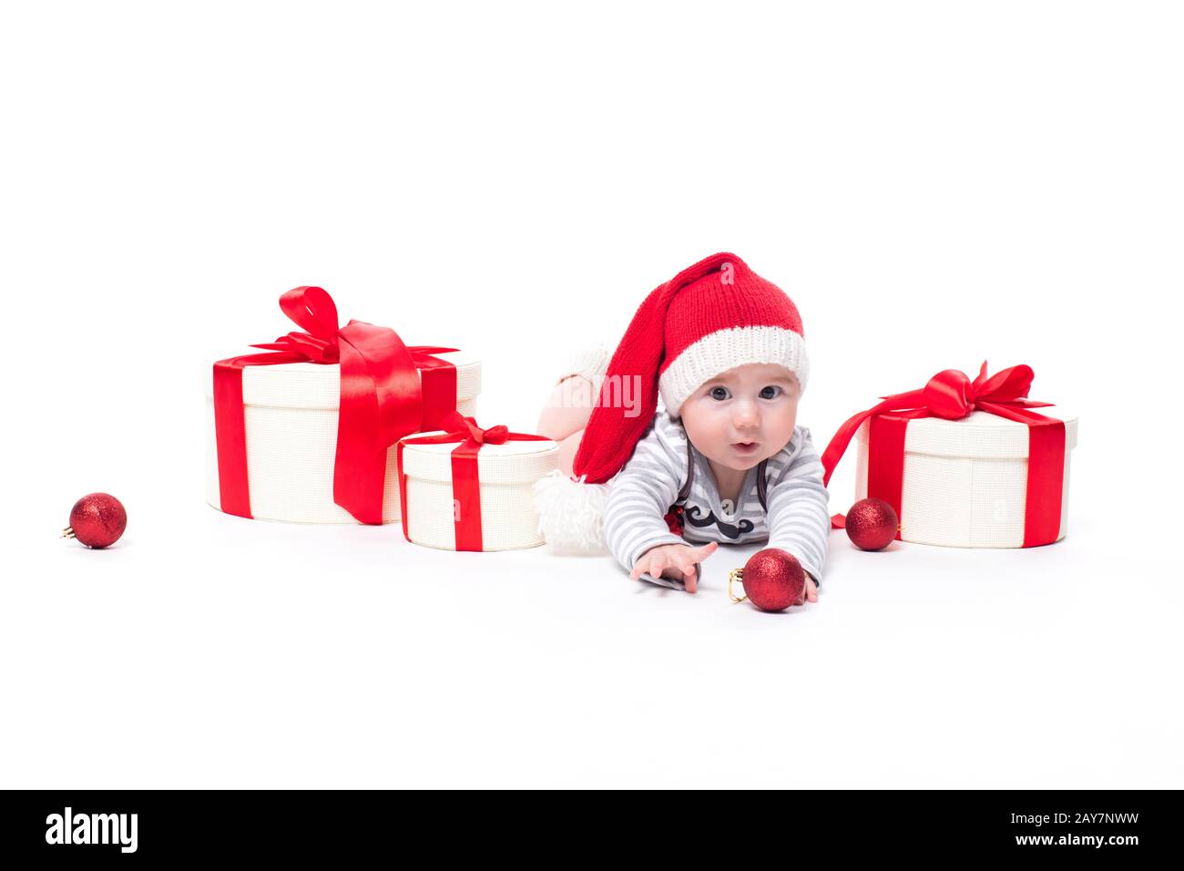 Bébé mignon dans une casquette rouge du nouvel an avec un sourire sur son visage allongé Banque D'Images