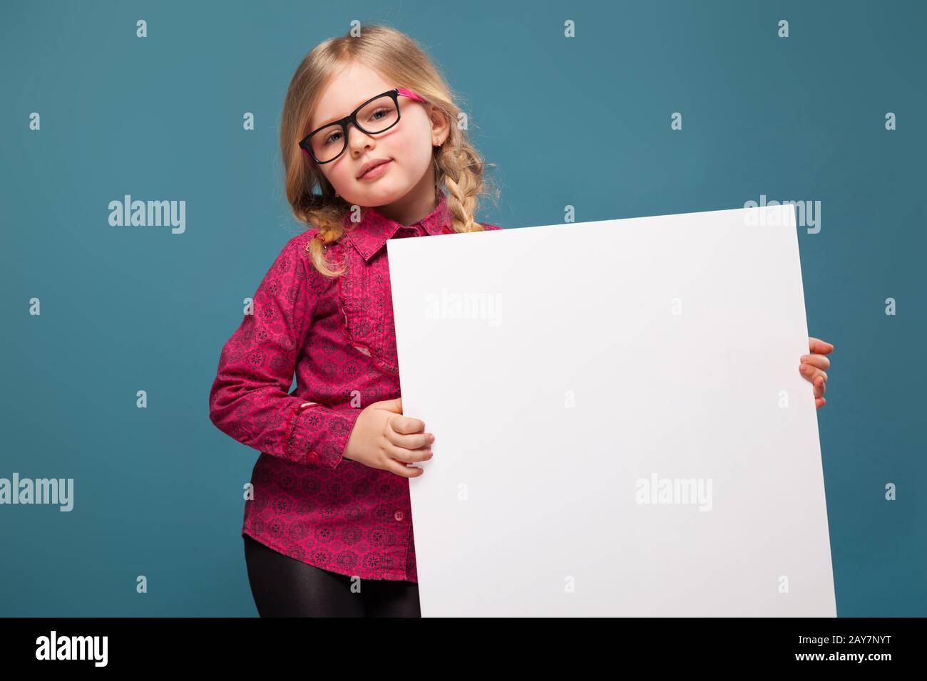 Adorable petite fille en chemise rose, pantalon noir et verres tient une  affiche vide Photo Stock - Alamy