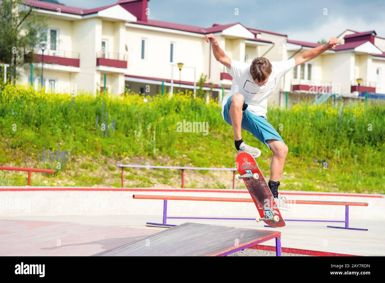 Un garçon dans un parc de skate faisant un tour sur un skateboard Banque D'Images