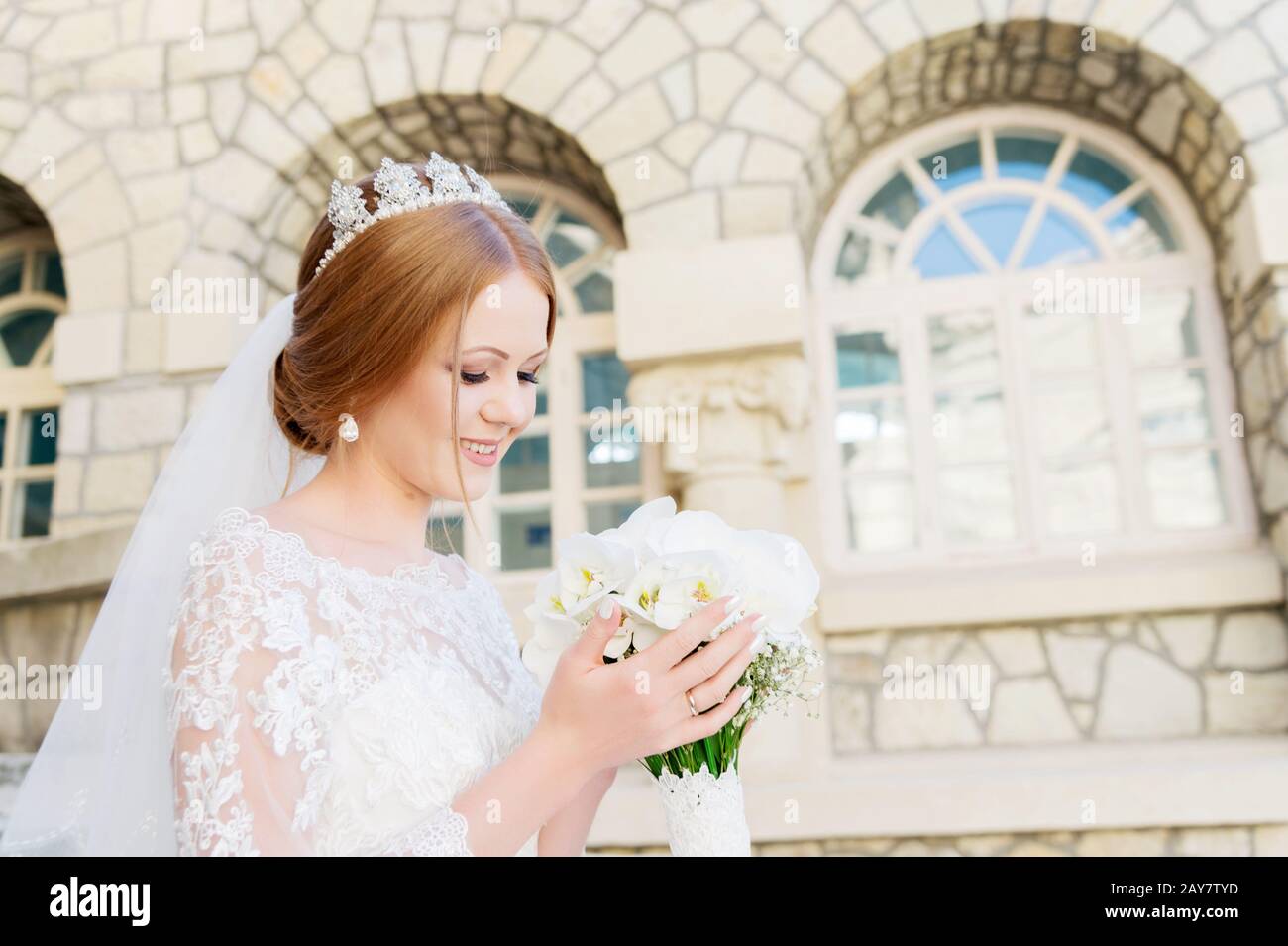 Portrait d'une belle mariée dans une robe blanche et un bouquet de fleurs dans ses mains Banque D'Images