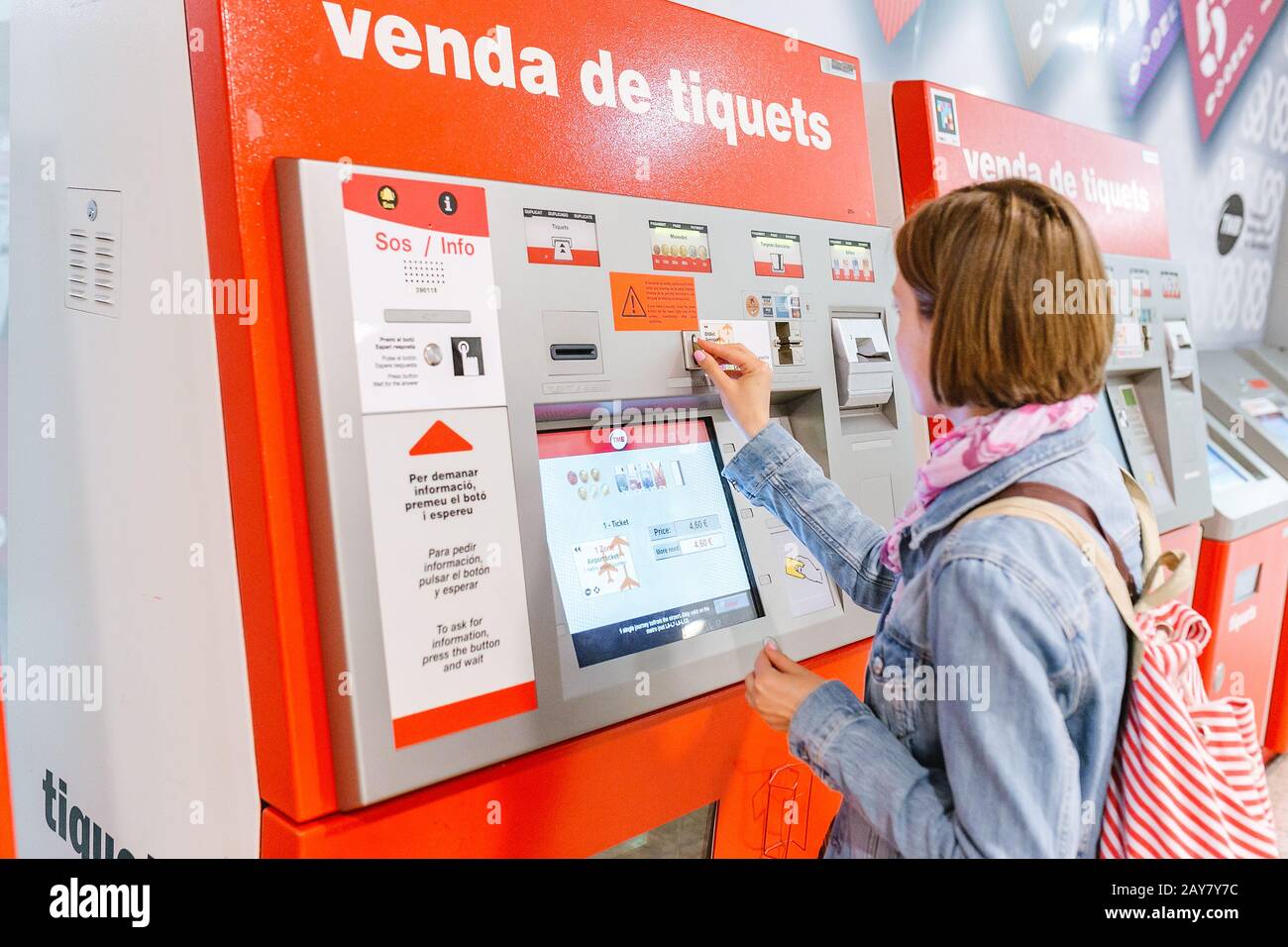 09 JUILLET 2018, BARCELONE, ESPAGNE: Une femme de voyage achetant un billet à un distributeur de billets de transport publice TMB à la station de métro Banque D'Images
