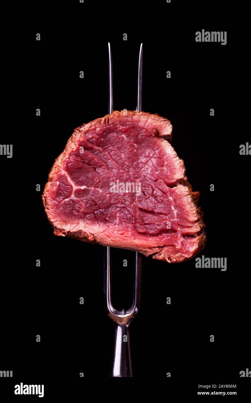 Morceau de steak sur une fourchette à viande Banque D'Images