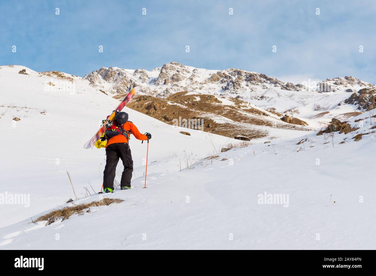 le freerider de ski monte la pente en poudre de neige profonde avec l'équipement à l'arrière fixé sur le sac à dos. Banque D'Images