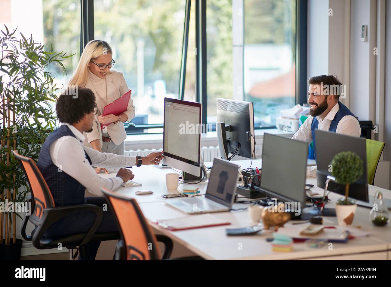 groupe de trois collègues dans le bureau de l'espace ouvert. travail d'équipe, succès, affaires Banque D'Images